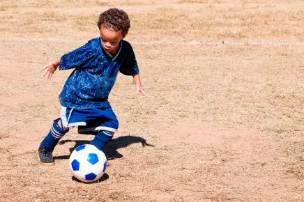 African American boy playing soccer.
