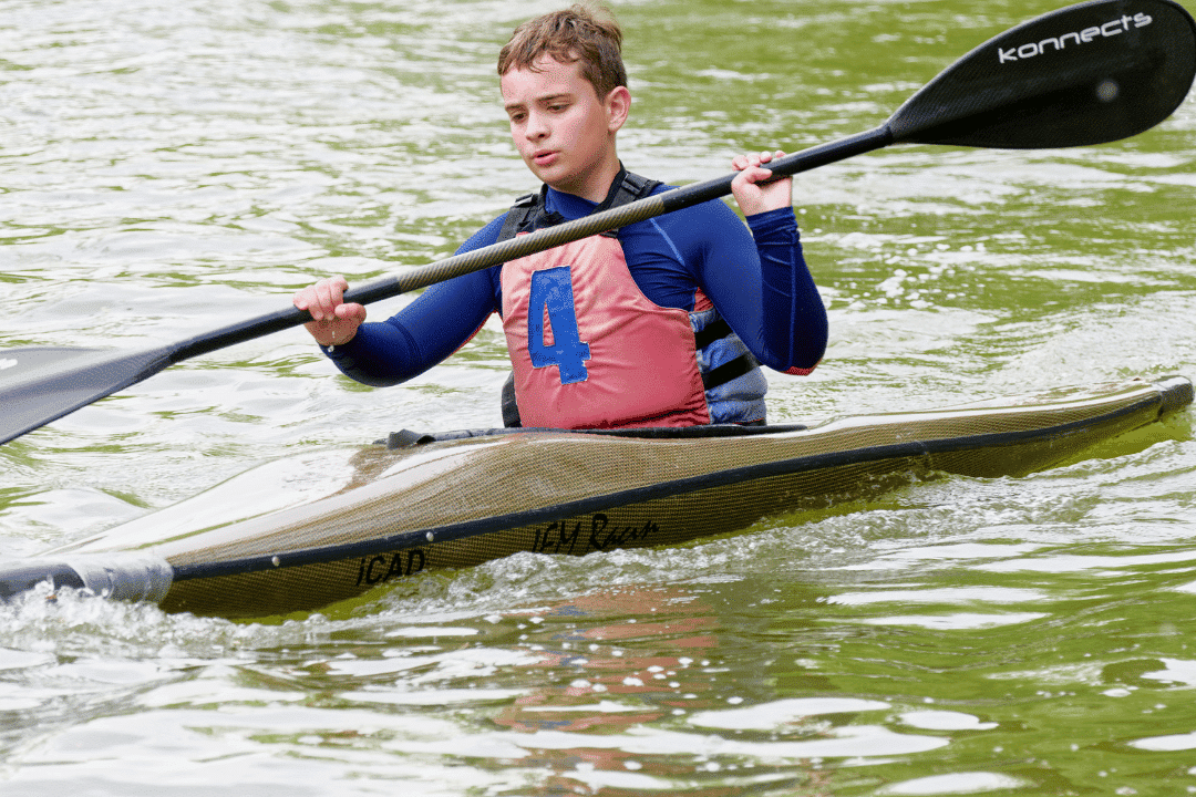 coy kayaking on a lake during camp activity