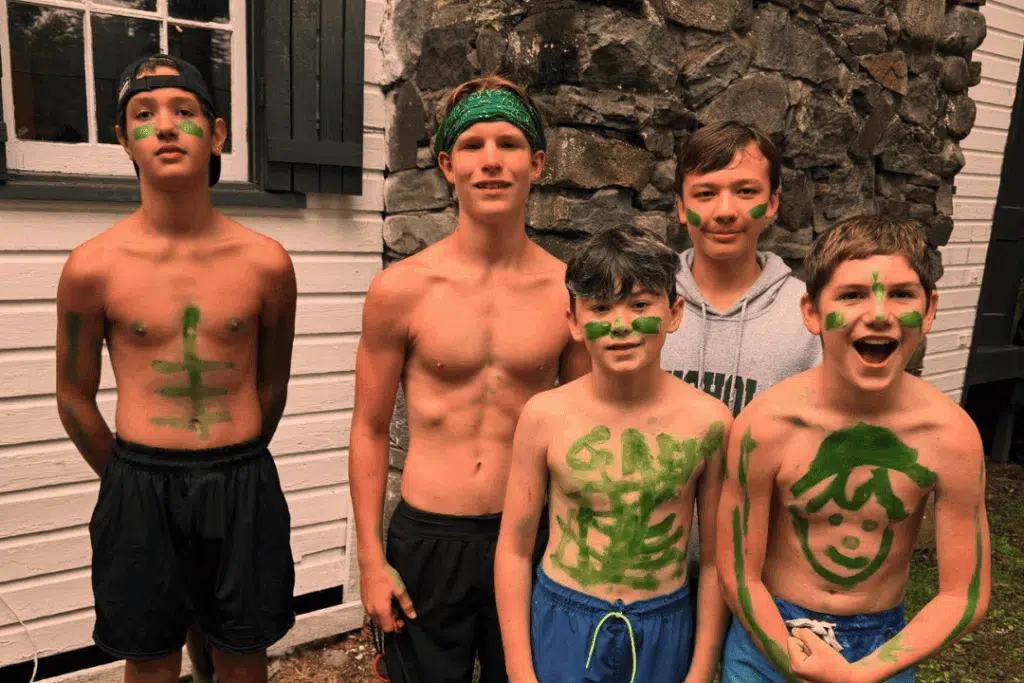 campers proudly displaying face and body paint during a spirited activity