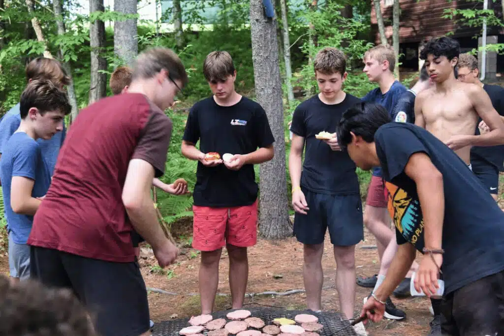 boys overnight camp campers cooking food outdoors teamwork and independence building skills